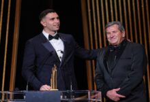 Two men in tuxedos stand side by side on stage