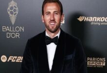 Harry Kane in a tuxedo poses confidently on a red carpet