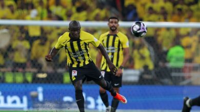 A soccer player in yellow and black uniform skillfully kicks the ball on the field