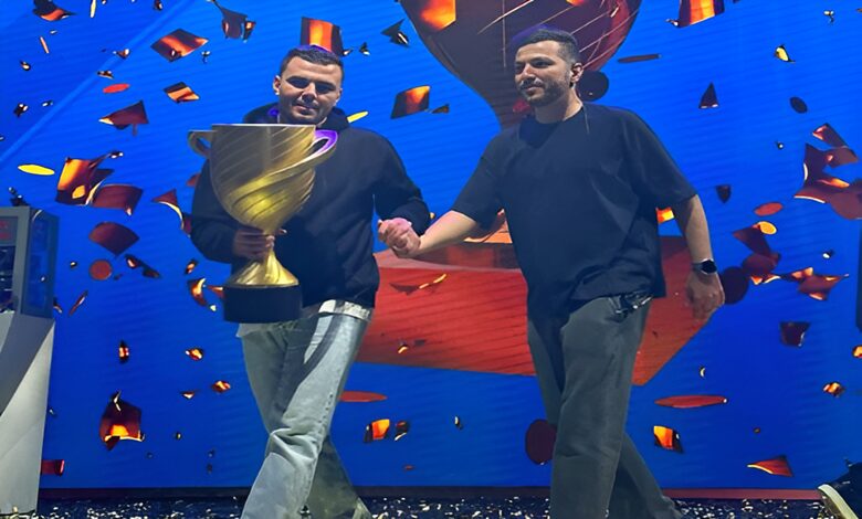 Yousef Masad And Dr Abdelaziz Ezzat proudly holding a large trophy on stage.