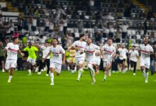 A group of soccer players sprinting across the field during a match