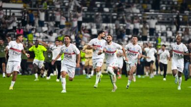 A group of soccer players sprinting across the field during a match