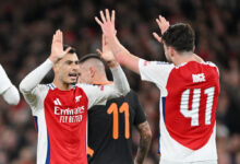 Arsenal player celebrates with teammates after scoring Arsenal's first goal during a match