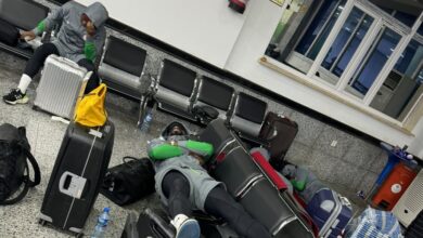 "Passengers resting with luggage in airport terminal."