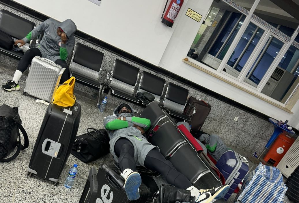 "Passengers resting with luggage in airport terminal."