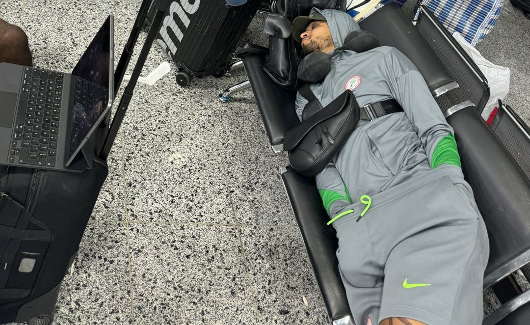 "Passenger resting with luggage in airport terminal."