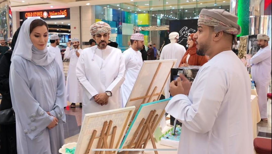 "People viewing artwork at an exhibition in a mall."