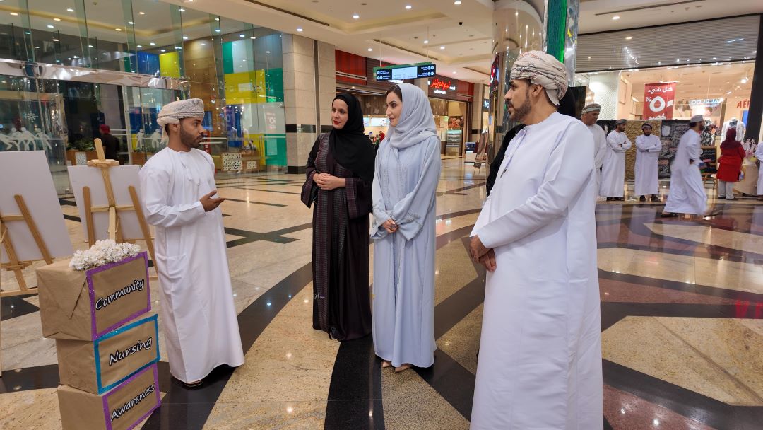 "Group of people in traditional attire at a community nursing awareness event in a mall."