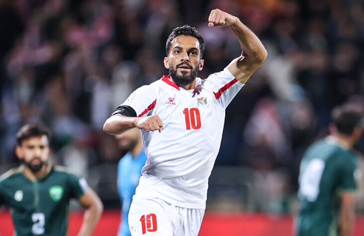 "Soccer player celebrating goal in white jersey number 10."