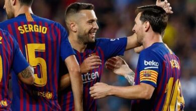 "Soccer players celebrating in blue and red striped jerseys."